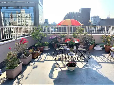 a balcony with a table and chairs and potted plants at Azabu House in Tokyo
