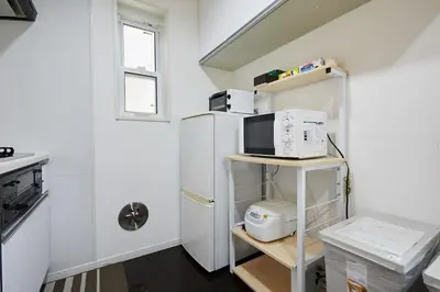 a small kitchen with a refrigerator and a microwave at Private Villa with Garage 10min to Ikebukuro Direct to Shinjuku, Shibuya & Airports in Tokyo