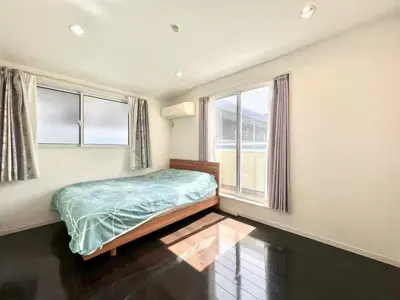 a bedroom with a bed and two windows at Private Villa with Garage 10min to Ikebukuro Direct to Shinjuku, Shibuya & Airports in Tokyo