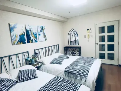 two beds in a bedroom with white and black pillows at \u6e0b\u8c37\u30cf\u30a6\u30b9\u6b65\u884c5\u5206\u949f\u5230\u6e0b\u8c37\u99c5 in Tokyo