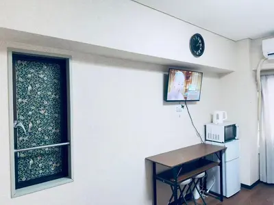 a room with a window with a desk and a microwave at \u6e0b\u8c37\u5bbf in Tokyo