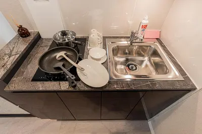 a kitchen counter with a sink and a frying pan at Mi-HOTEL Kitashinjuku in Tokyo