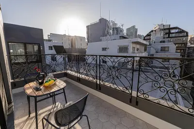 a balcony with a table and chairs on a balcony at Mi-HOTEL Kitashinjuku in Tokyo