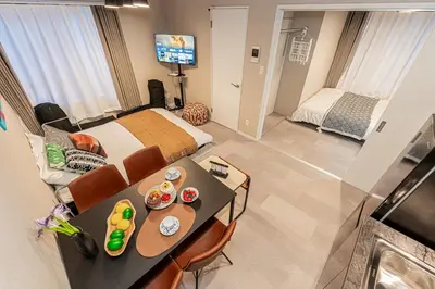 a bedroom with a bed and a table with food on it at Mi-HOTEL Kitashinjuku in Tokyo
