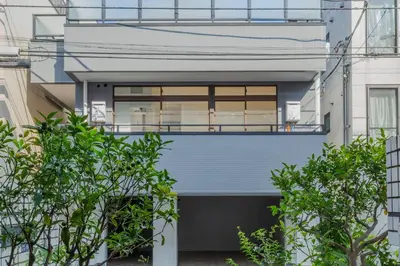 a house with a blue facade with trees at ISSHUKU Noma \u5317\u65b0\u5bbfI -301 Triple Room in Tokyo