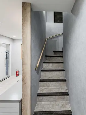 a staircase in a house with concrete walls at ISSHUKU Noma \u5317\u65b0\u5bbfI -301 Triple Room in Tokyo