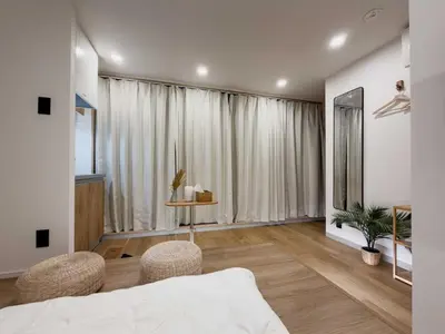 a bedroom with a bed and two chairs and a window at ISSHUKU Noma \u5317\u65b0\u5bbfI -301 Triple Room in Tokyo