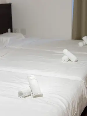 two rolls of white towels on a white bed at ISSHUKU NOMA\u6c60\u888bII 101 - Spacious Room for 5 Guests in Tokyo