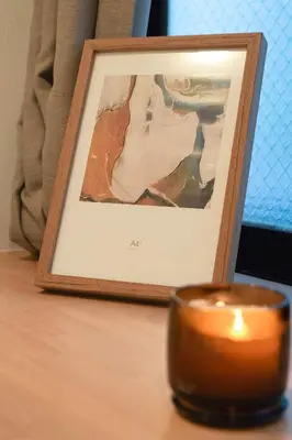 a candle on a table next to a picture at ISSHUKU Noma \u5317\u65b0\u5bbfI -302 Quad Room in Tokyo