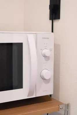 a white microwave oven sitting on top of a table at ISSHUKU Noma \u5317\u65b0\u5bbfI -302 Quad Room in Tokyo