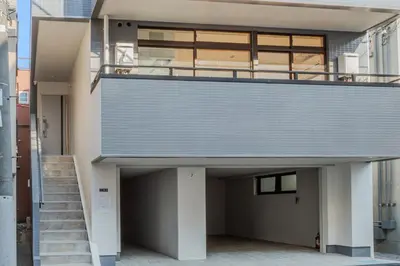 a building with a garage with a staircase on it at ISSHUKU Noma \u5317\u65b0\u5bbfI -302 Quad Room in Tokyo