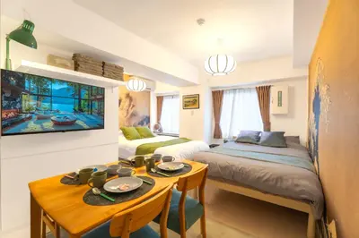a room with two beds and a table with plates on it at \u99c5\u5f92\u6b695\u5206 Sugamo Yasu Hotel in Tokyo