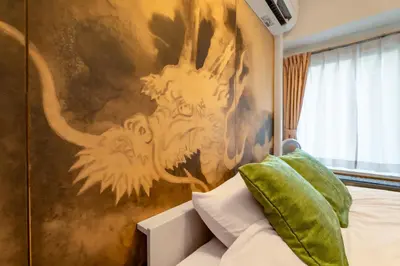 a bedroom with a painting of a lion on the wall at \u99c5\u5f92\u6b695\u5206 Sugamo Yasu Hotel in Tokyo