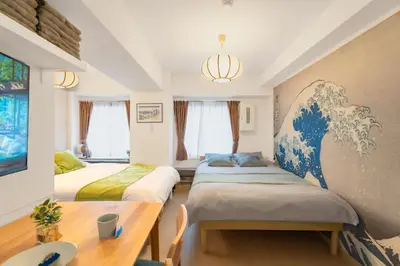 two beds in a room with a large painting on the wall at \u99c5\u5f92\u6b695\u5206 Sugamo Yasu Hotel in Tokyo