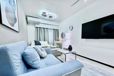 a living room with a blue couch and a flat screen tv at Kabukicho Designer's Apt VIII in Tokyo