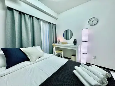 a bedroom with a bed and a desk with a clock at Kabukicho Designer's Apt VIII in Tokyo