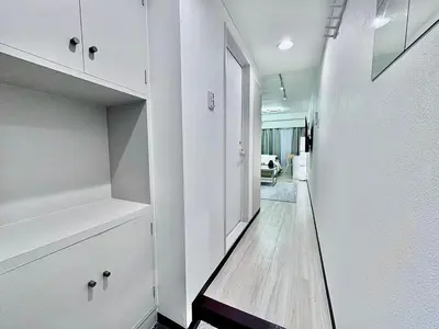 a hallway with white cabinets and a walk in closet at Kabukicho Designer's Apt VIII in Tokyo