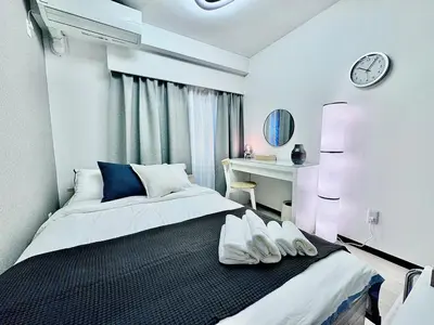 a bedroom with a bed and a desk with a clock at Kabukicho Designer's Apt VIII in Tokyo