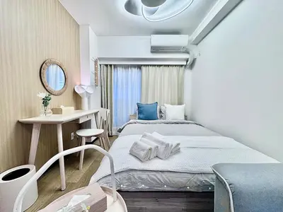 a bedroom with a bed and a table and a mirror at Kabukicho Designer's Apt X in Tokyo