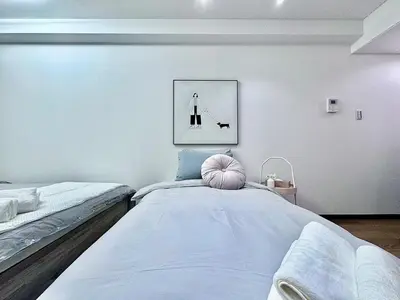 a bedroom with two beds and a picture on the wall at Kabukicho Designer's Apt X in Tokyo