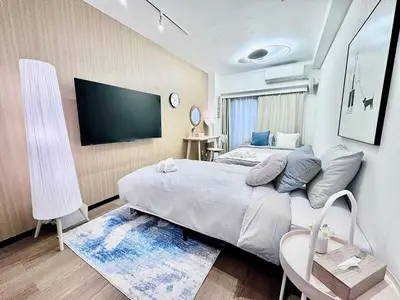 a bedroom with a bed and a flat screen tv at Kabukicho Designer's Apt X in Tokyo