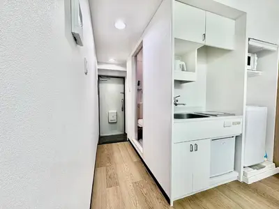 a white kitchen with white cabinets and a sink at Kabukicho Designer's Apt X in Tokyo