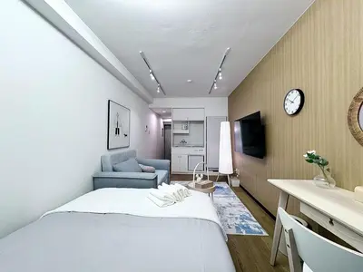 a room with a bed and a couch and a clock at Kabukicho Designer's Apt X in Tokyo