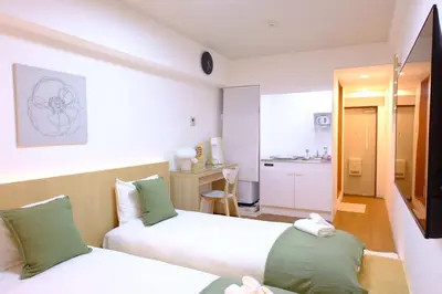a hotel room with two beds and a kitchen at Shinjuku Kabukicho Apt XI in Tokyo