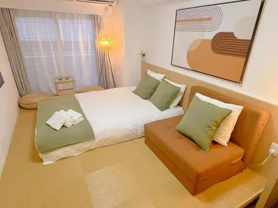 a small bedroom with a bed and a chair at Shinjuku Kabukicho Apt XI in Tokyo