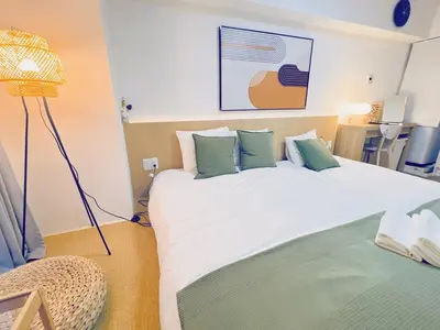 a bedroom with a large white bed with green pillows at Shinjuku Kabukicho Apt XI in Tokyo