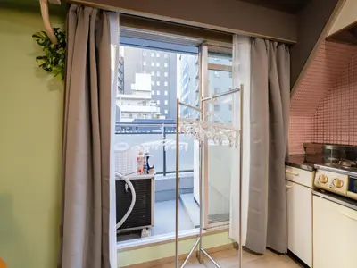 a kitchen with a large window with a balcony at 4min Shibuya Sta,3min Shinsen Sta,Central Shibuya,family-friendly,Switch, movies, Wi-Fi in Tokyo