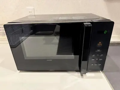 a black microwave oven sitting on top of a counter at Central Tokyo Skytree Heven in Tokyo