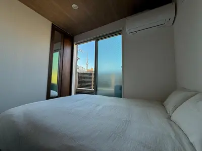 a bedroom with a white bed and a large window at Central Tokyo Skytree Heven in Tokyo