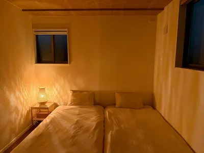a bedroom with a bed and a lamp and two windows at Central Tokyo Skytree Heven in Tokyo