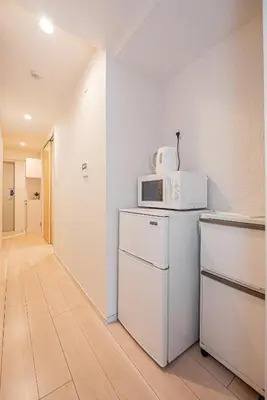 a kitchen with a microwave and a refrigerator at Louis stage asakusa in Tokyo