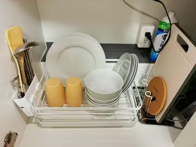 a dish rack in a kitchen with plates and dishes at \u6696\u71c8 DANTO inn 4F in Tokyo