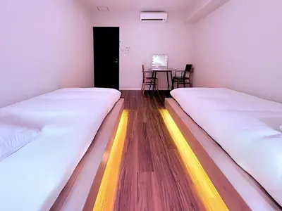 two beds in a room with a table and chairs at Spacious Family Stay Shinagawa-Kokoro House in Tokyo