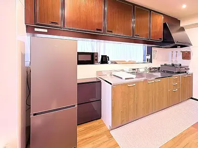 a kitchen with stainless steel appliances and wooden cabinets at Spacious Family Stay Shinagawa-Kokoro House in Tokyo