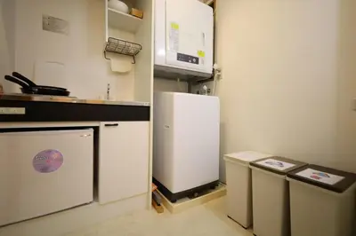 a kitchen with a white refrigerator and a microwave at Hatsudai Guest House GRINDEL in Tokyo