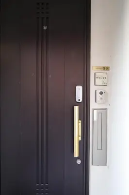 a black door with a yellow handle on a building at Hatsudai Guest House GRINDEL in Tokyo