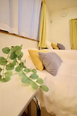 a bedroom with a bed with a plant on a table at Hatsudai Guest House GRINDEL in Tokyo