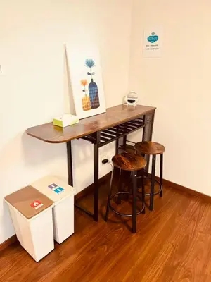 a wooden table with two stools in a room at Nexus Villa Morishita in Tokyo