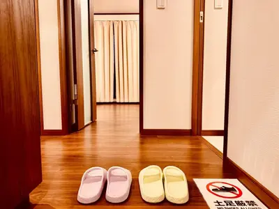 two pairs of shoes sitting on the floor in a hallway at Nexus Villa Morishita in Tokyo