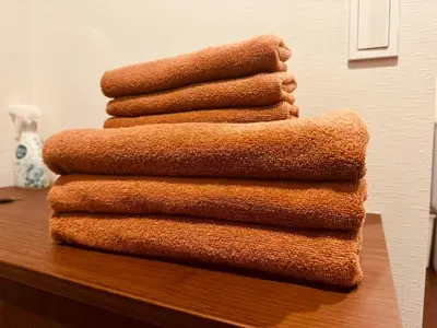 a stack of towels sitting on top of a table at Nexus Villa Morishita in Tokyo