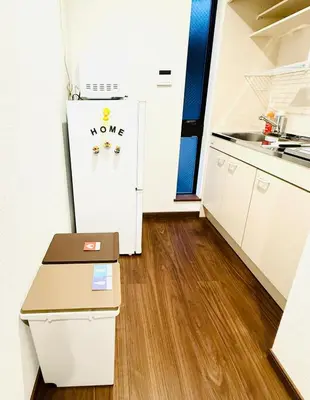 a kitchen with a refrigerator and a table at Nexus Villa Morishita in Tokyo