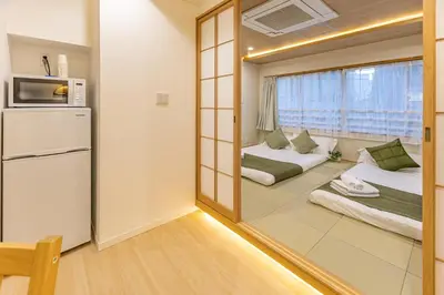 a small room with two beds and a mirror at New mansion 5 mins from Yoyogi stations in Tokyo