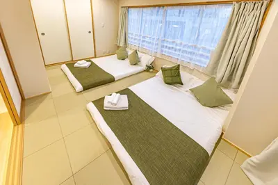 two beds in a room with a window at New mansion 5 mins from Yoyogi stations in Tokyo