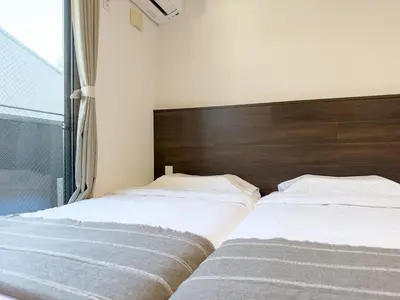 two beds sitting next to each other in a bedroom at ISSHUKU NOMA\u6c60\u888bII 102 - Quad Room in Tokyo