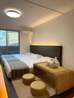 a bedroom with a large bed and two stools at ISSHUKU NOMA\u6c60\u888bII 102 - Quad Room in Tokyo