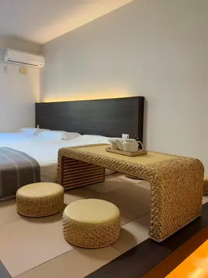 a bedroom with a bed and a table and two stools at ISSHUKU NOMA\u6c60\u888bII 102 - Quad Room in Tokyo